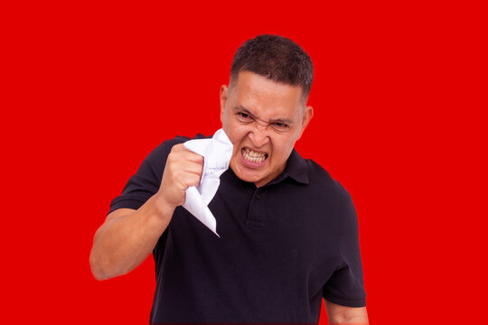 An angry man going amok crumpling his bills, showing irrational compulsive behavior and blind rage. Isolated on a white background.