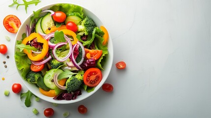 Vibrant fresh vegetable salad in white bowl on white surface, concept of healthy eating and nutrition