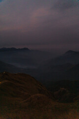 Obraz premium A mountain range with a dark sky in the background
