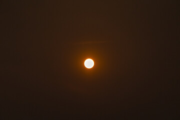 A large, bright yellow sun is in the center of a dark sky