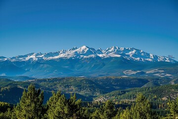 The mountain range has snow-capped peaks and pine forests.