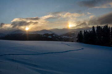 sunrise casting two reflections of the sun in the snow