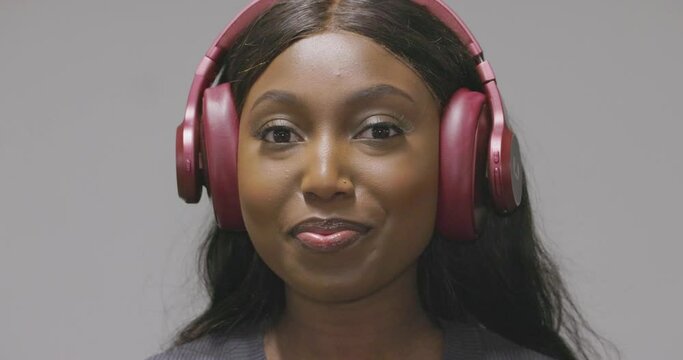 Captured in a moment of leisure, a young woman with a joyful expression listens to music or engaging audio content through her headphones. The images radiate her enjoyment and connection to the sound