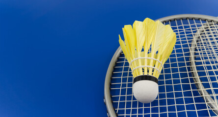 Yellow feather shuttlecock on badminton racket