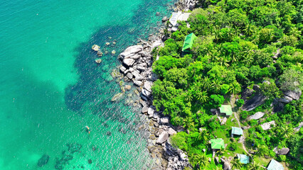 Verdant woodlands fringe the shore, where striking rock features contrast with the tranquil azure...