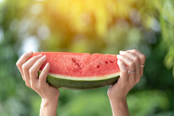Women eat red watermelon organic hand holding red fruit high vitamins outdoor on tropical beach...