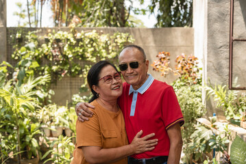 A happy old asian couple in a nice embrace. Senior citizen husband and wife celebrating 40th anniversary. Outdoor scene.