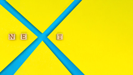 黄色い背景でNEXTのアルファベットのXをデザインした青色の装飾