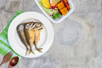 Deep fried mackerel fish and vegetable salad on  grey cement floor texture background, healthy...
