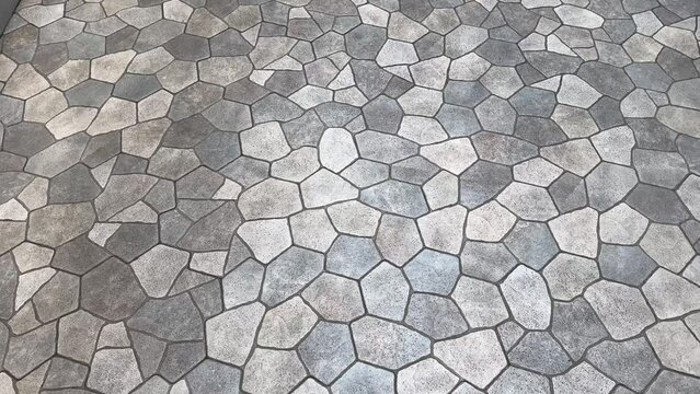 4K video. Seamless flagstone outdoor paving textures, or cobblestone cut flat in random pieces, grey, light grey, charcoal color. Monochrome stone slabs. Pavement and landscape paving stone background