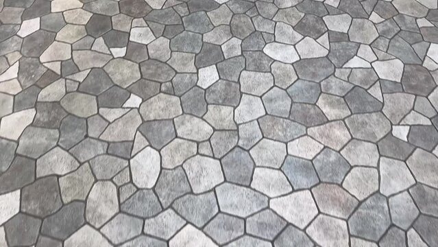 4K video. Walkthrough. Seamless flagstone outdoor paving textures, or cobblestone cut flat in random pieces, grey, light grey, charcoal color. Monochrome stone slabs. Pavement floor paving stone.