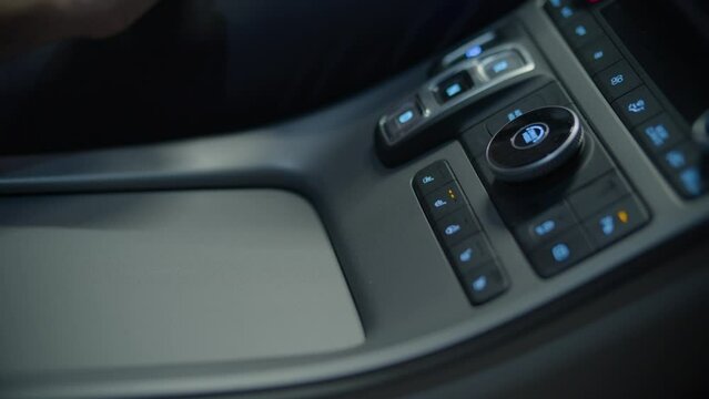 acercamiento de una mano para tocar un bot&oacute;n en un auto