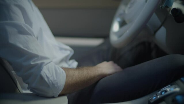 Persona moviendo el asiento de su auto hacia adelante