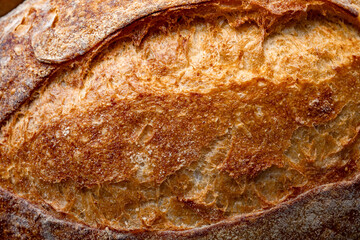 A close view of a freshly baked sourdough bread with a textured, golden crust.