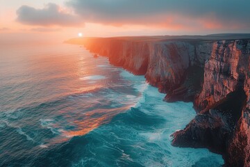 Aerial view of rugged cliffs meeting the crashing waves at sunrise
