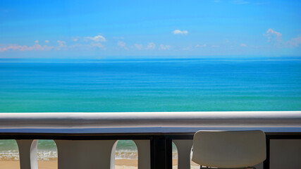 blank seaside working space terrace with white bar stool and balcony and blurred blue sea in...