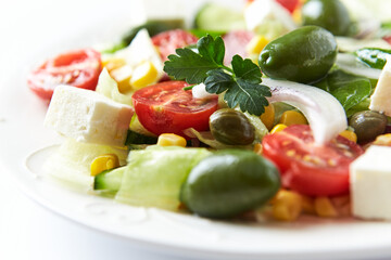 Healthy Salad with Feta Cheese, Green Olives, Baby Spinach, Cucumber, Cherry Tomatoes and Capers. Bright background. Close up.	