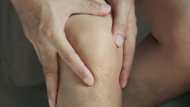 Man with knee pain, he puts his hand on his knee, pain point from osteoarthritis and osteoarthritis, medical concept and treatment	