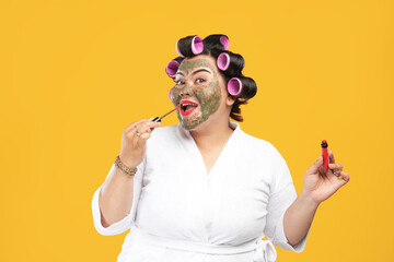 portrait of a fat and happy housewife wearing a natural mask and lipstick isolated on a yellow...