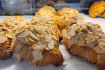 Fresh baked butter croissants with almond on tray in pastry shop
