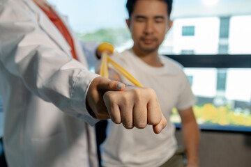 A physical therapist is helping a patient perform basic physical therapy stretches to relax the muscles, The physical therapy process takes place by experts in the physical therapy room.