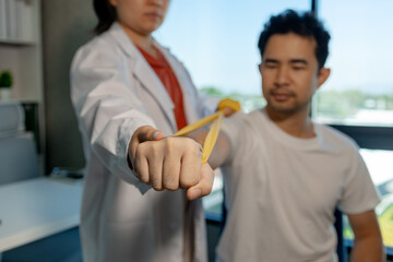 A physical therapist is helping a patient perform basic physical therapy stretches to relax the muscles, The physical therapy process takes place by experts in the physical therapy room.