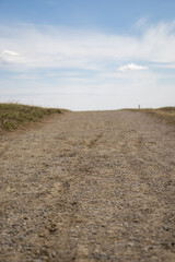 Fototapeta na wymiar Empty Dirt Road under Clear Blue Sky
