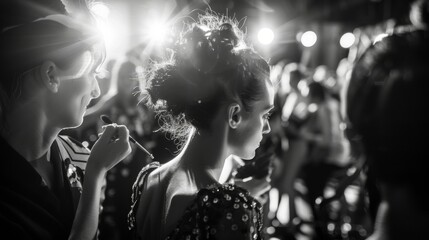 Defocused drama Amid the bright lights and high energy of a fashion show the backstage area is a scene of organized chaos. Makeup artists and hairdressers work feverishly on models .