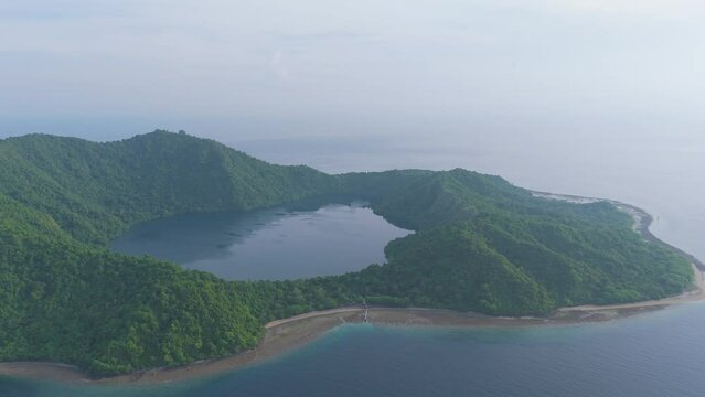 Sumbawa, Indonesia. A large island with a green forest and a blue ocean. The island is surrounded by water and has a large crater in the middle