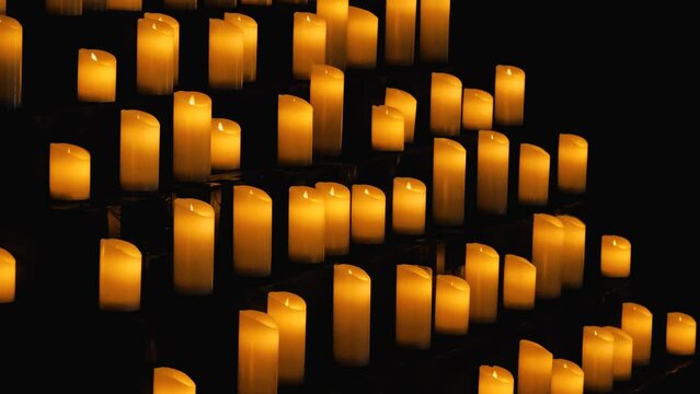 A multitude of lit candles whose flames cast a warm, soft light. The scene radiates a sense of calm and peace, symbolising purification, healing and blessing