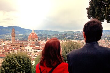 Tourists man and woman look at panorama of historical center of Florence in Italy from Piazzale...