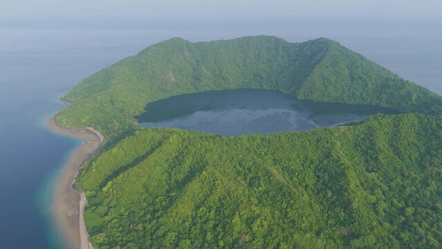 Sumbawa, Indonesia. A large island with a green forest and a blue ocean. The island is surrounded by water and has a large crater in the middle
