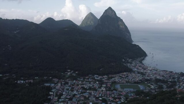Aerial drone of Petit Piton and Gros Piton.  A UNESCO world heritage site located on the Caribbean island nation of Saint Lucia.  The city of Soufriere can be seen below the peaks of the mountains.