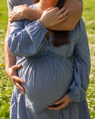 Pregnancy photo: man and woman holding pregnant belly while expecting baby. Happy family holding...