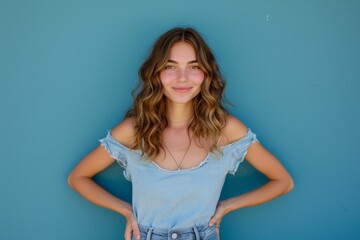 Smiling Caucasian woman posing with hands on hips isolated on blue background