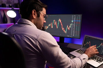 Smart trader businessman concentrating on dynamic stock exchange investment on pc and laptop...