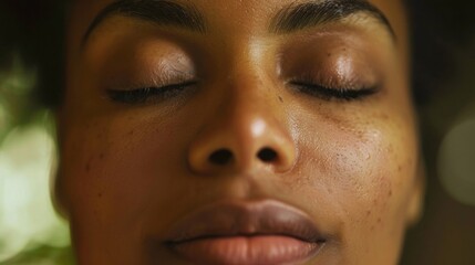 Closeup of a persons face showing a serene expression as they take a deep breath and let go of any stress or fears focusing on finding solutions and moving forward. .