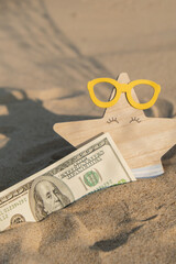 Money american hundred dollar bills in sandy beach with starfish. Concept finance saving money for...