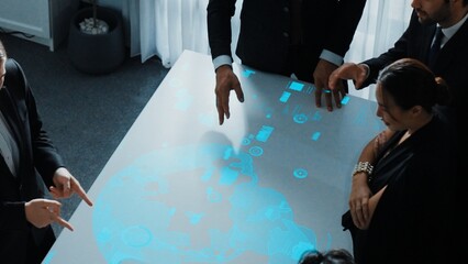 Top view of project manager looking hologram of global networking connection table surrounded by...