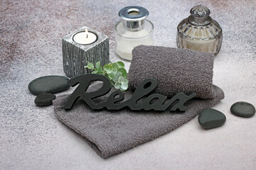 Spa composition with towel candle and hot stone.
