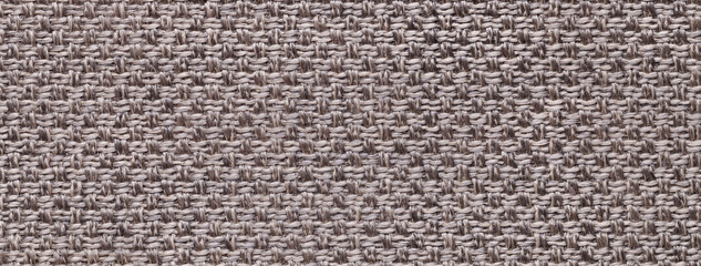 Texture of brown color background from woven textile material with wicker pattern, macro. Vintage fabric cloth,