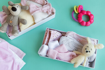 Baby and child clothes and knitted toys in carton box.