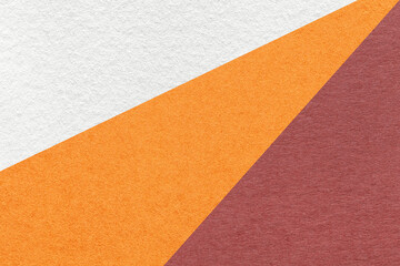 Texture of old craft white, orange and maroon color paper background, macro. Vintage abstract cardboard