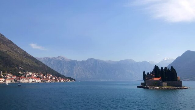 Boats sailing out to the island of Saint George with the historic town of Perast in the background. Bay of Kotor. Adriatic Sea. Perast, Montenegro. Europe.