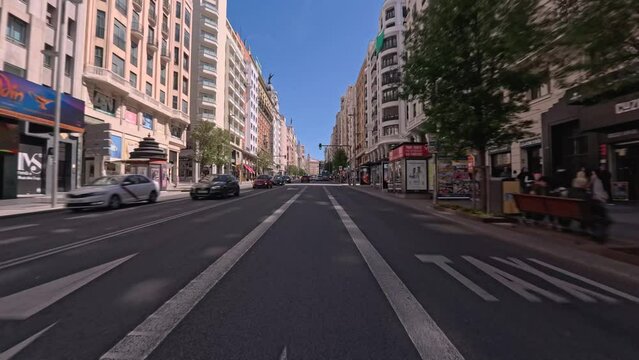 Driver's Point Of View POV from a motorbike through Gran V&iacute;a street in Madrid on a sunny day from Spain Square to Callao Square with buses, taxis and cars circulating. Madrid                      