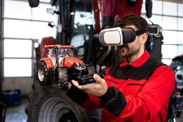 Serviceman using virtual reality glasses and tractor model in workshop.