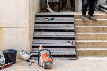 Concrete steps under construction as a team of builders install heavy concrete blocks