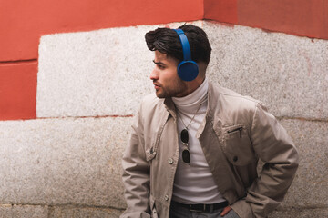 Stylish colombian male model listening to music and looking to the side.