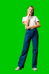 Young Woman in White Shirt Posing for Picture against green background - obrazy, fototapety, plakaty