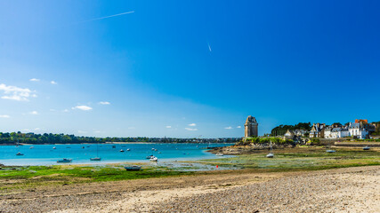 Panoramic view of the Solidor Tower in Saint-Malo in Brittany, under a blue sky and at low tide.